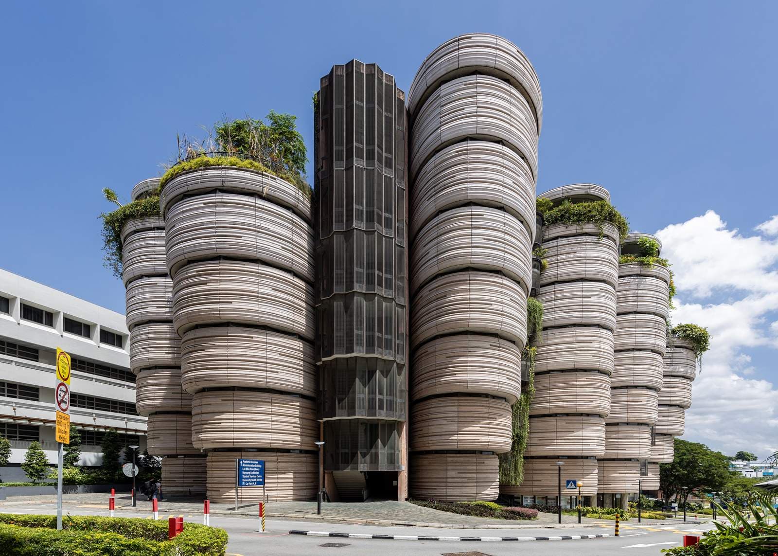 The Hive at Nanyang Technological University: a cluster of rounded, stacked concrete towers with plants spilling from the tops, under a blue sky